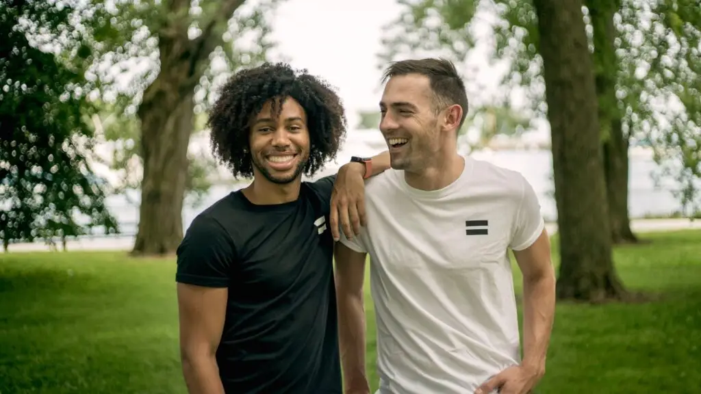 Two friends laughing and enjoying a sunny day at a park in Chicago.